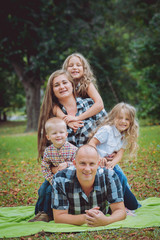 Fototapeta premium Young family with cheerful children in the park