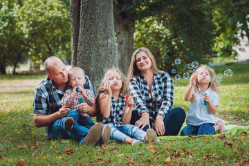 Fototapeta premium Young family with cheerful children in the park