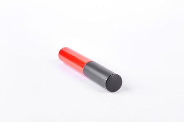 Red liquid lipstick with black cap. Beautiful red liquid lipstick isolated on white background. Woman makeup accessory.