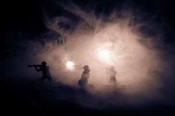 Naklejka na ściany i meble War Concept. Military silhouettes fighting scene on war fog sky background, World War Soldiers Silhouettes Below Cloudy Skyline At night. Attack scene. Armored vehicles. Selective focus