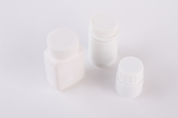 Three plastic bottles for pills. Blank medicine bottles isolated on white background.