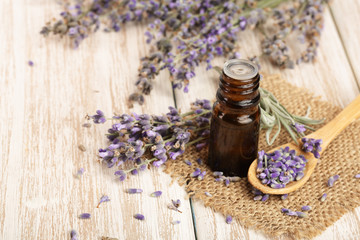 Obraz na płótnie Canvas Herbal oil and lavender flowers on wooden background