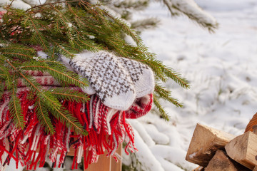 Scandinavian style wool mittens on the Christmas plaid near firewood
