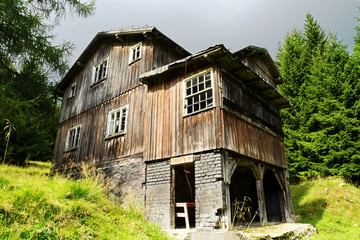 Old abandoned scary wooden house on a forest glade. The Owl Mountains Landscape Park, Sudetes,...