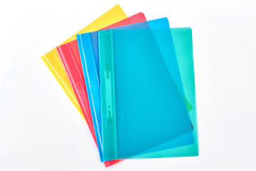 Multicolored transparent folders for documents. Four different colors file folders isolated on white background, top view.