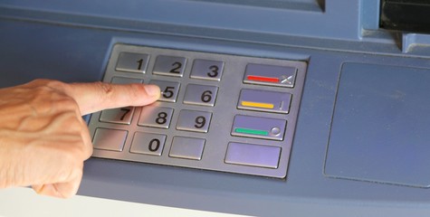 woman typing the secret code on the ATM keyboard