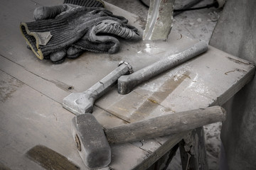 Gli strumenti dello scultore: guanti, martello e scalpelli