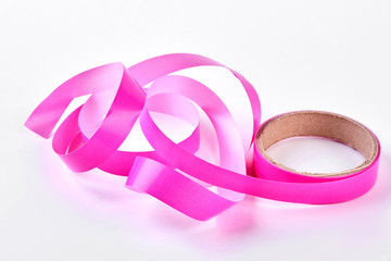 Pink tape for gift packaging. Roll of beautiful pink ribbon isolated on white background.