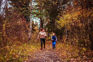 Obraz premium Little boy and his sister running in autumn forest