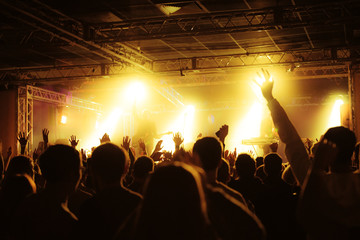 silhouettes of concert crowd in front of bright stage lights