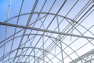 Metal frame of a greenhouse against the sky