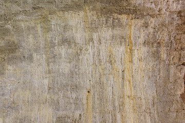 The old gray wall of natural stone with rusty stains