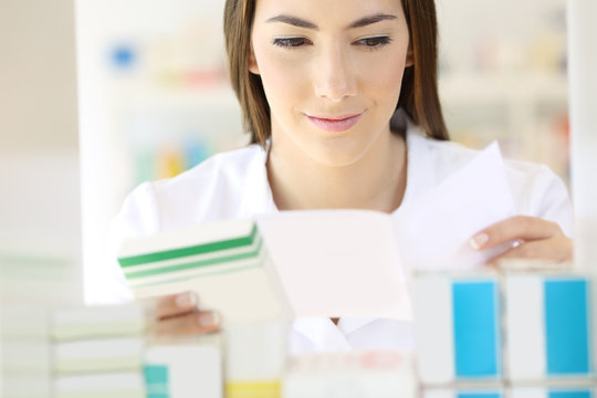 Pharmacist reading prescription preparing medicine