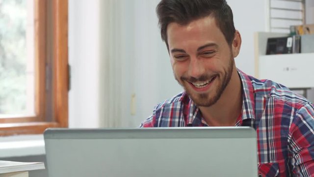A young man communicates via video communication on a computer