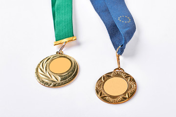 Gold medals on white background. Two golden medals isolated on white background. Victory and prize concept.
