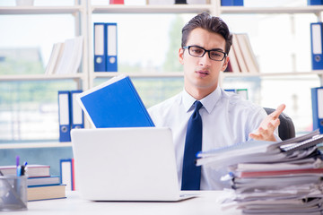 Obraz na płótnie Canvas Businessman with excessive work paperwork working in office