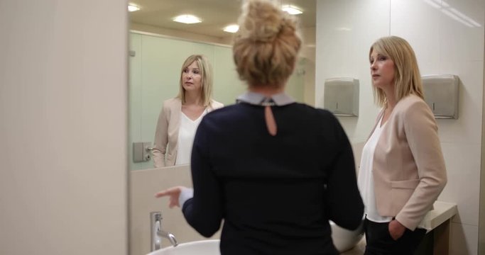 Businesswomen talking in restroom