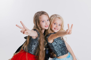 beautiful twq little girls with curly blonde hairstyles on the holiday party in dress with sequins...
