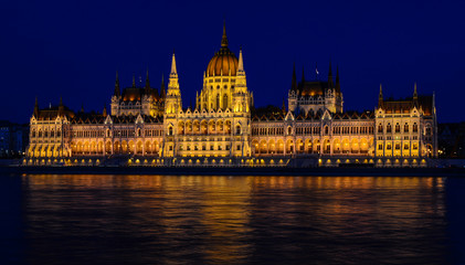 Panoramic view of Hungarian Parliament reflecting in Danube river. Night cityscape of Budapest