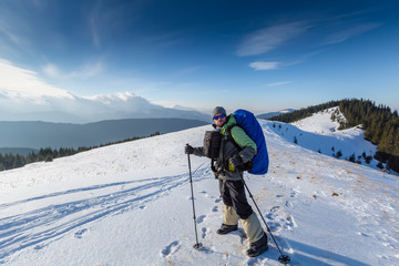 Fototapeta na wymiar Hiker is posing to the camera in winter mountains