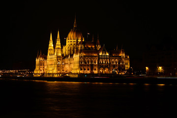 Panoramic view of Hungarian Parliament reflecting in Danube river. Night cityscape of Budapest
