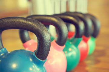 Colorful kettlebells in a row in a gym