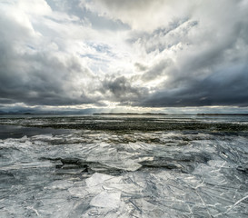 Winter Landscape frozen lake with ice floes and cloudy sky in Ic