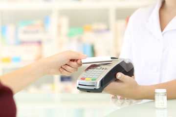 Customer paying with credit card reader in a pharmacy