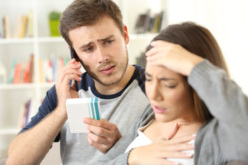 Man helping his wife calling doctor on phone