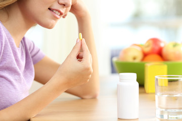 Obraz na płótnie Canvas Close up of a girl taking vitamin pill
