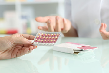 Girl buying contraceptive pills in a pharmacy - obrazy, fototapety, plakaty