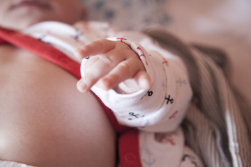 little baby hand, tummy and belly button in the bed