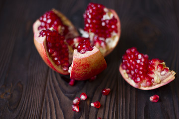 ruby pomegranate seeds in a clay bowl on wooden table