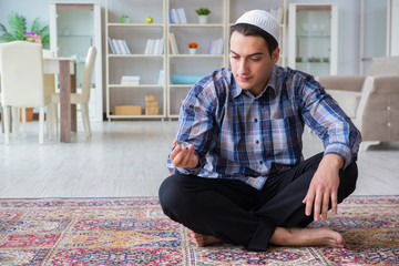 Fototapeta premium Young muslim man praying at home