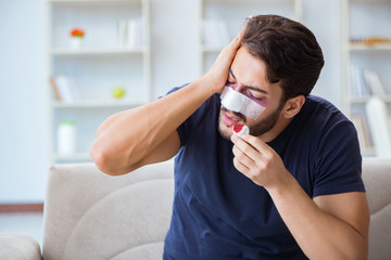 Young man recovering healing at home after plastic surgery nose 