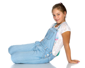 A teenage girl is sitting on the floor.