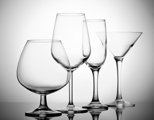 A variety of empty glasses for alcoholic beverages.
