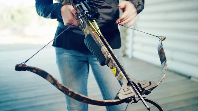 Girl inserts arrow into crossbow