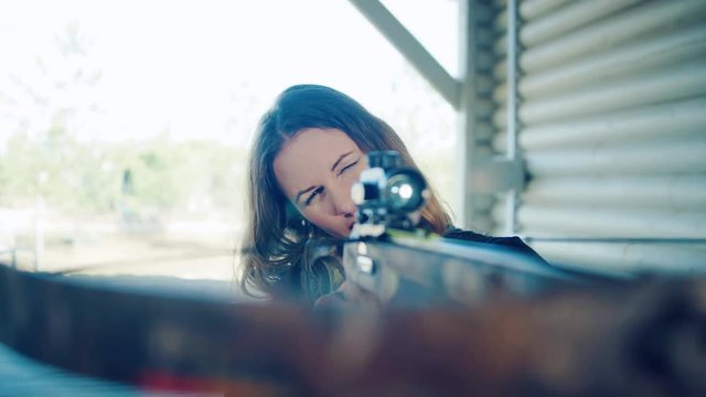 The pretty girl takes aim the crossbow