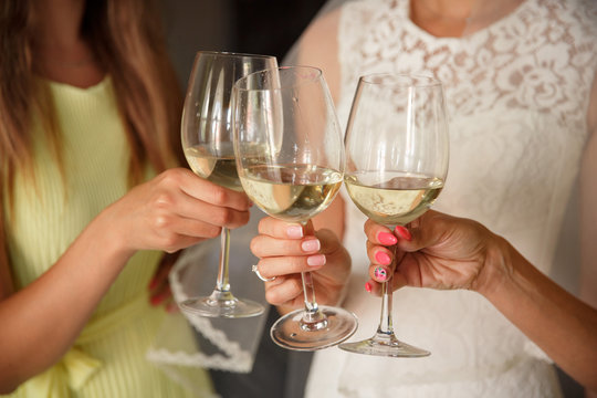 Wedding party, bride clinks to the bridesmaids with champagne glasses. Wedding or hen party concept
