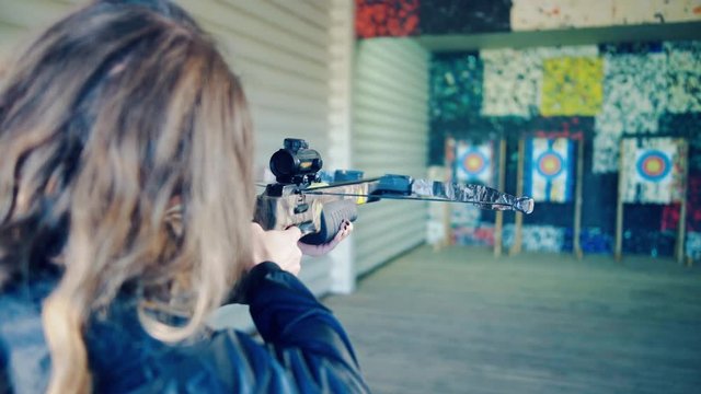 The blonde girl takes aim the crossbow
