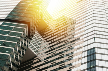 Obraz premium Modern glass building business center. Skyscraper in the city. The sun's rays are reflected in the glass surface of the building. Bottom view.