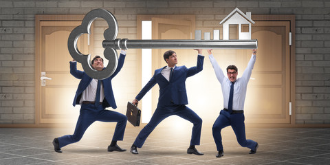 Businessmen holding giant key in real estate concept