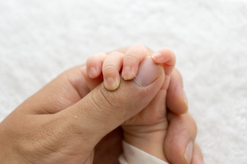 Obraz na płótnie Canvas Newborn baby touching his father hand