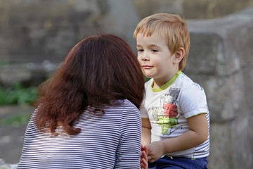 A woman is talking with her little beloved son. The crisis of three years with the boy. The boy...