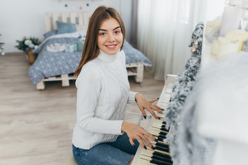 A beautiful girl play the piano on Christmas Day.