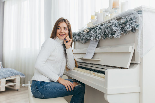 A beautiful girl play the piano on Christmas Day.