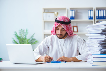 Arab businessman working in the office doing paperwork with a pi