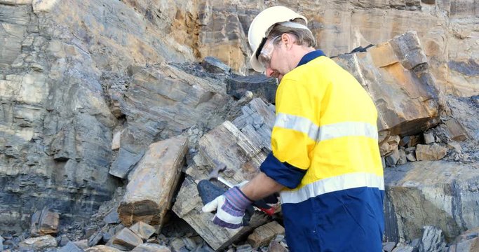 Geologist engineer man examines coal sedimentary layer for mining industry