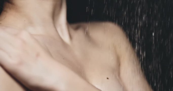 Woman taking shower in slow motion 120fps.Young sexy attractive woman standing under the pouring water, close up on body curves. Beauty concept. Filmed in 4K DCi RAW. Dolly shot.